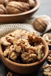 Photo of Fresh ripe walnuts in bowl on table, closeup