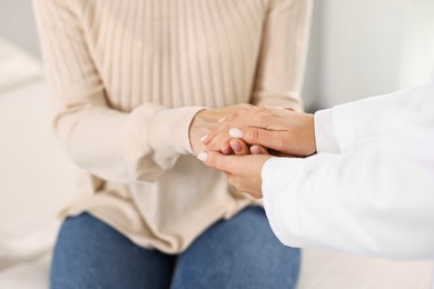 Photo of Doctor supporting patient during appointment in hospital, closeup of hands