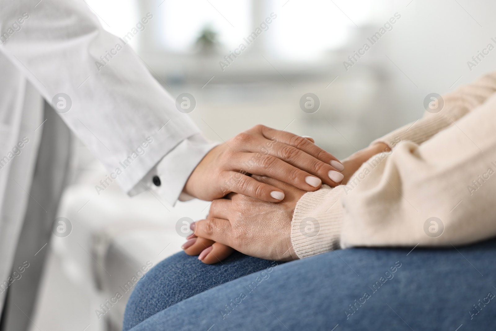 Photo of Doctor supporting patient during appointment in hospital, closeup of hands