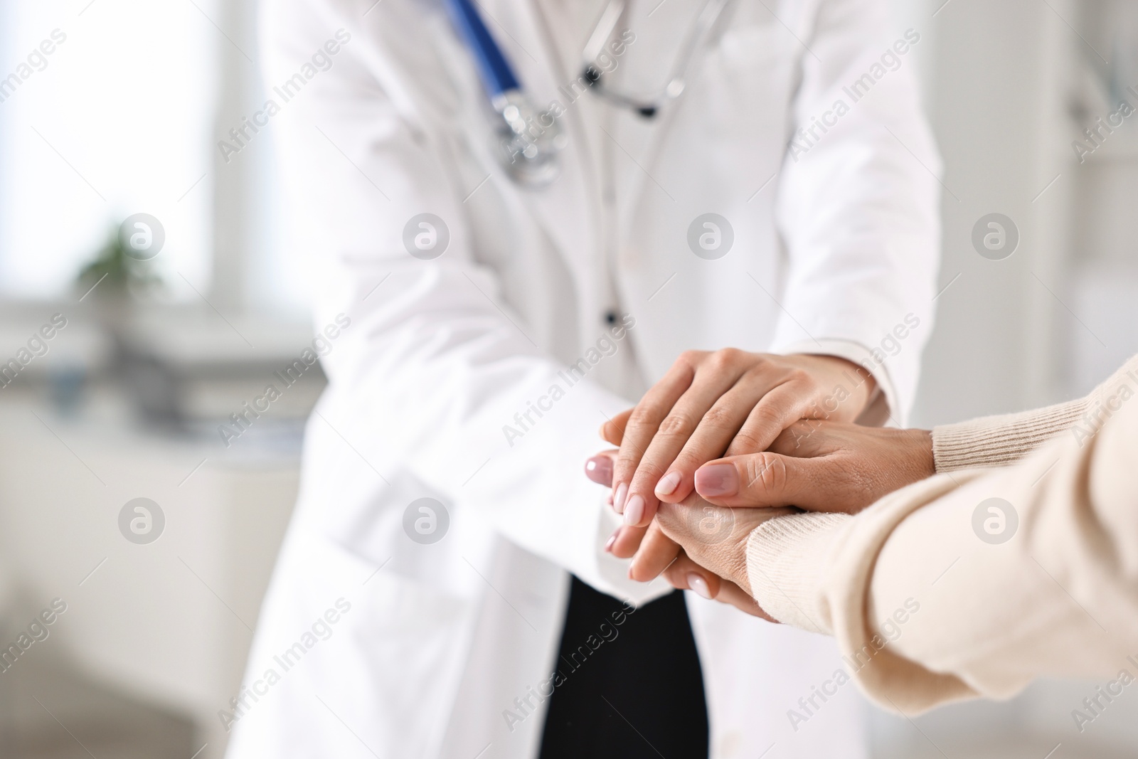 Photo of Doctor supporting patient during appointment in hospital, closeup of hands