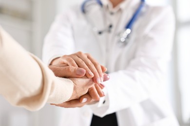 Photo of Doctor supporting patient during appointment in hospital, closeup of hands