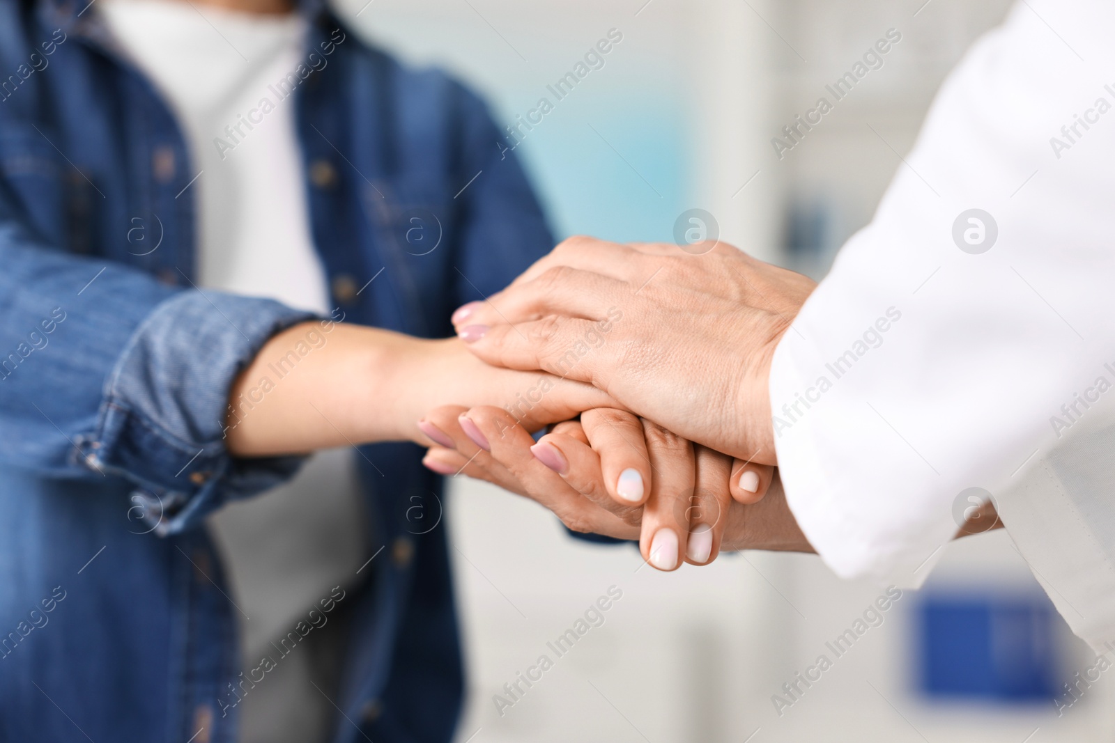 Photo of Doctor supporting patient during appointment in hospital, closeup of hands