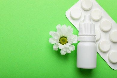 Photo of Allergy treatment. Nasal drops, pills and flower on green background, flat lay. Space for text