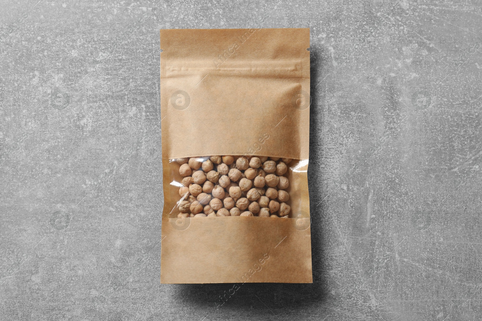 Photo of Paper pouch bag with chickpeas on grey table, top view