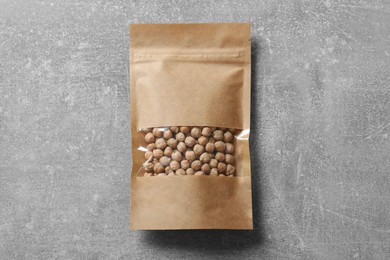 Photo of Paper pouch bag with chickpeas on grey table, top view