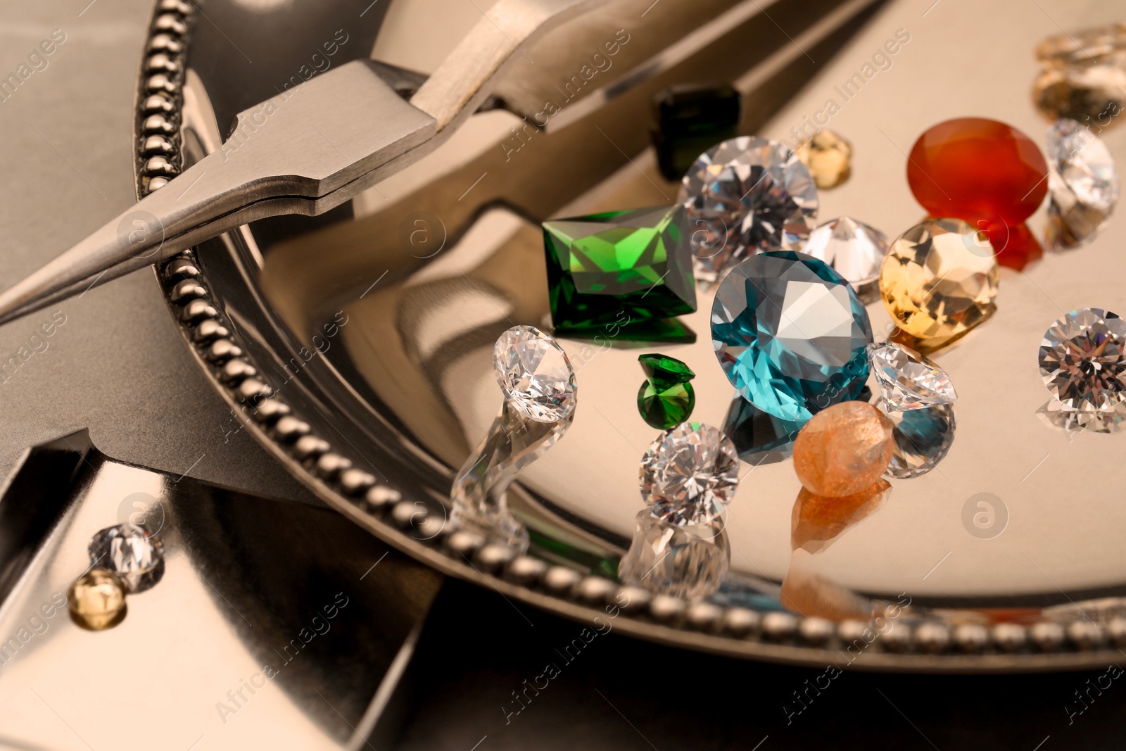 Photo of Tray with beautiful gemstones on light table, closeup