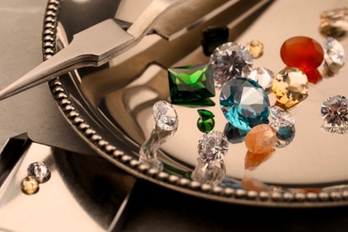 Photo of Tray with beautiful gemstones on light table, closeup