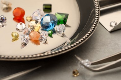 Photo of Tray with beautiful gemstones on light table, closeup