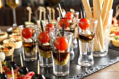 Photo of Many different tasty canapes on wooden table, closeup