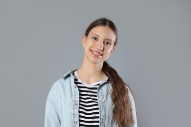 Photo of Portrait of smiling teenage girl on grey background