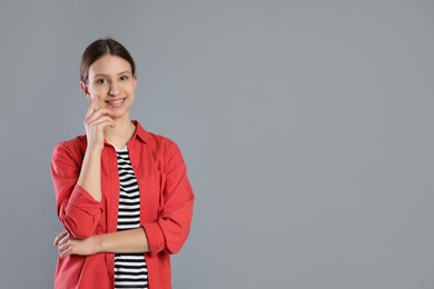 Photo of Portrait of smiling teenage girl on grey background. Space for text