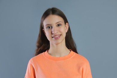 Photo of Portrait of smiling teenage girl on grey background