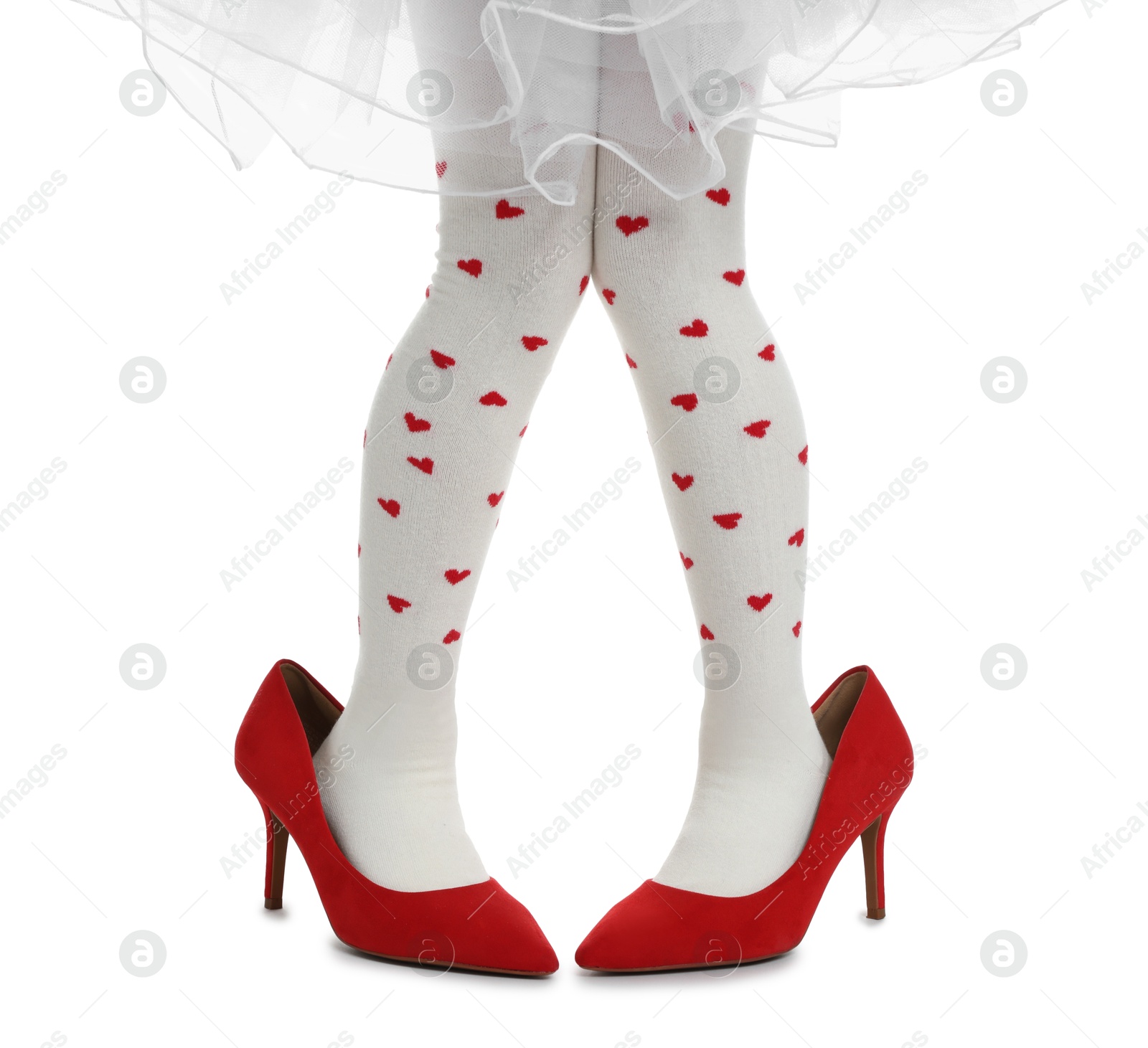 Photo of Little girl wearing oversized high heeled shoes on white background, closeup