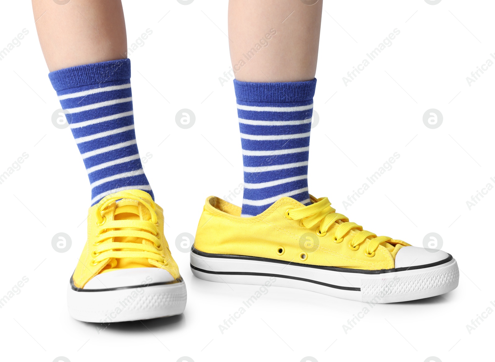 Photo of Child wearing oversized yellow sneakers on white background, closeup