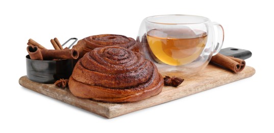 Photo of Delicious cinnamon roll buns with tea and spices isolated on white