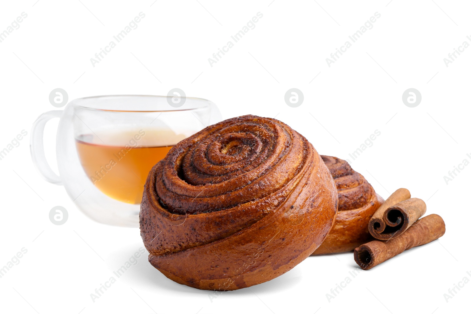 Photo of Delicious cinnamon roll buns with tea and spices isolated on white