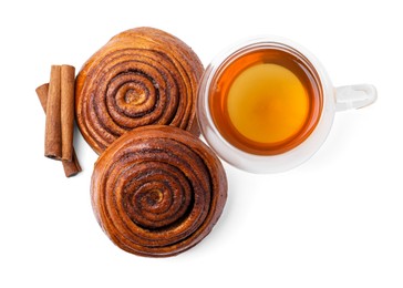 Photo of Delicious cinnamon roll buns with tea and spices isolated on white, top view