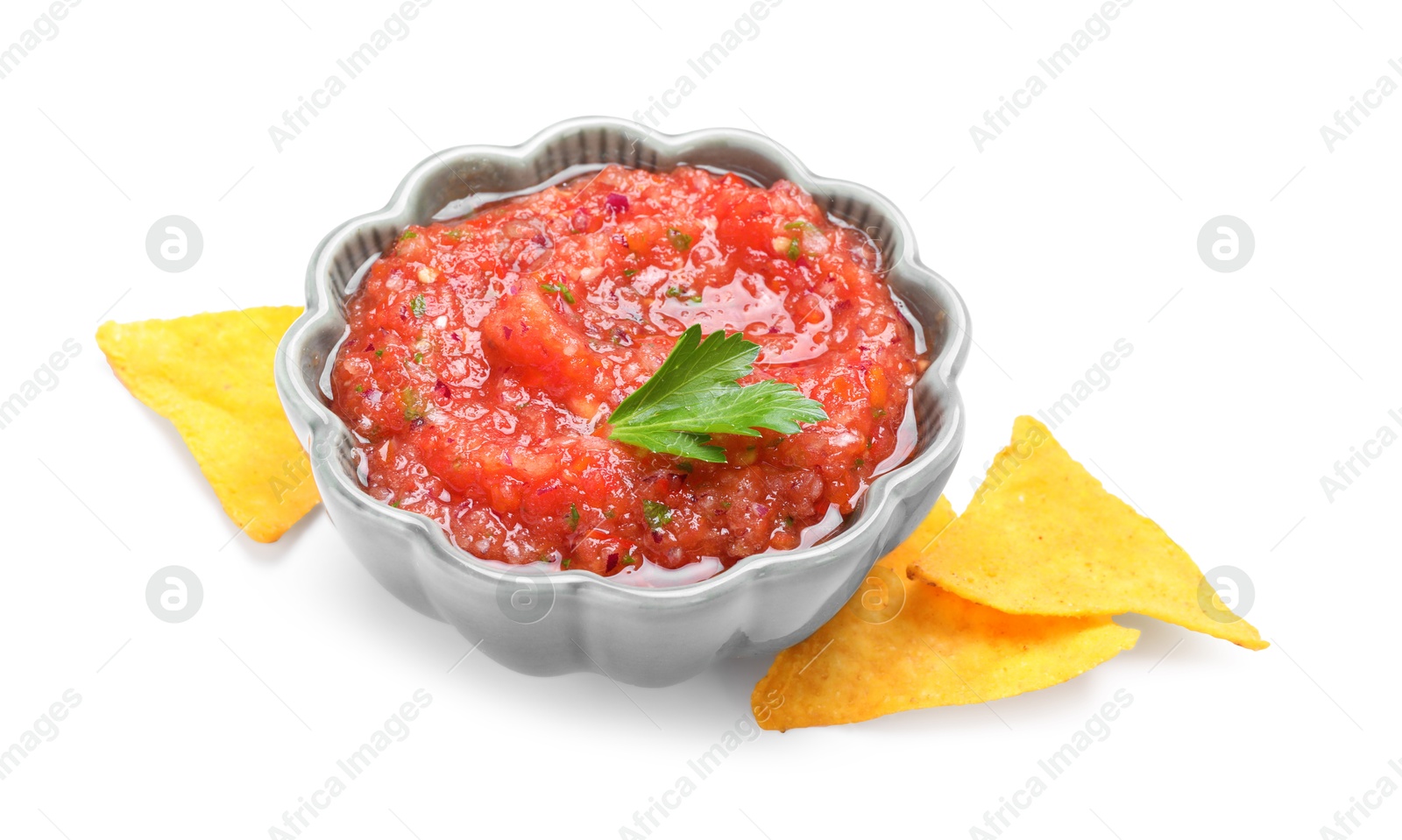 Photo of Delicious spicy salsa sauce in bowl and nacho chips isolated on white