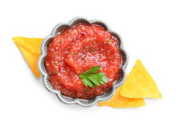 Delicious spicy salsa sauce in bowl and nacho chips isolated on white, top view