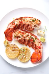 Photo of Delicious lobster tails with lemon, microgreens and green onion on white table, top view