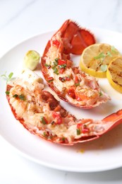 Delicious lobster tails with lemon, microgreens and green onion on white table, closeup