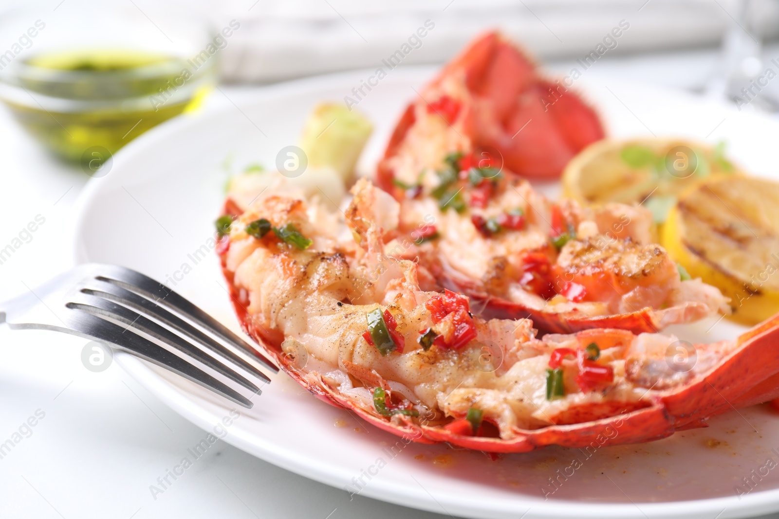 Photo of Delicious lobster tails with green onion on white table, closeup