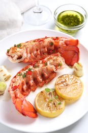 Photo of Delicious lobster tails with lemon, microgreens and green onion on white table, above view