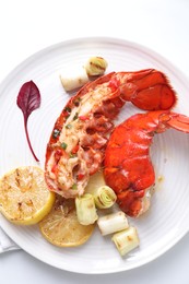 Delicious lobster tails with lemon and green onion on white table, top view