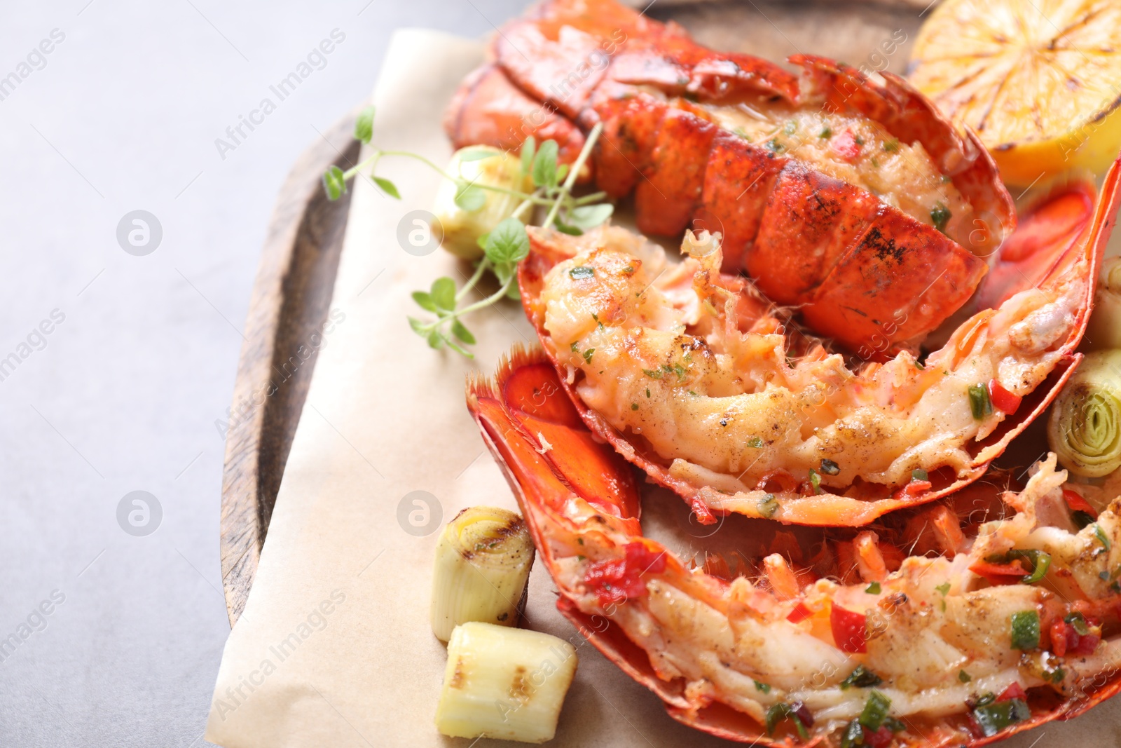 Photo of Delicious lobster tails with microgreens and green onion on light table, above view