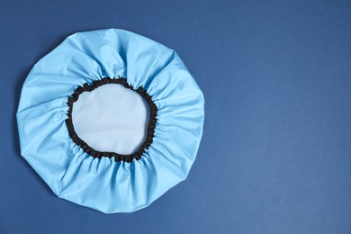 Photo of One shower cap on blue background, top view. Space for text