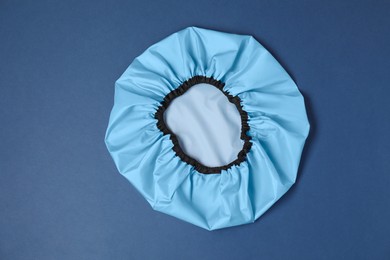 Photo of One shower cap on blue background, top view