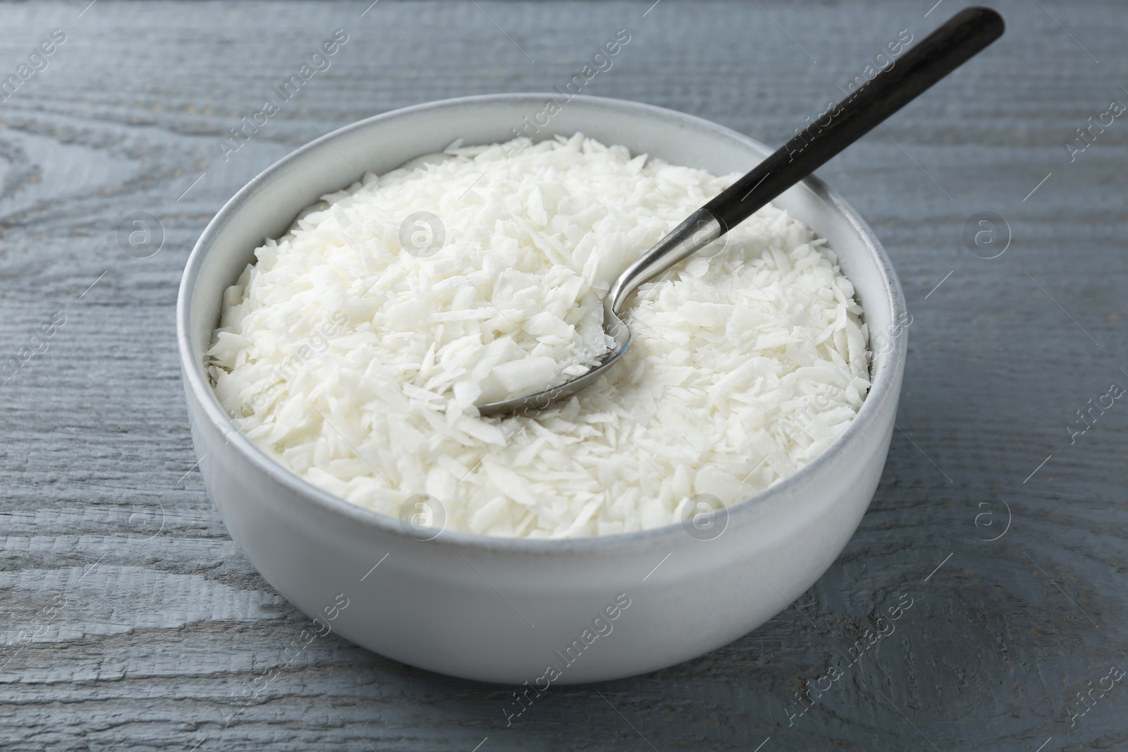 Photo of Soy wax in bowl on grey wooden table