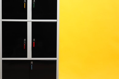 Photo of Modern lockers with keys on orange background, space for text