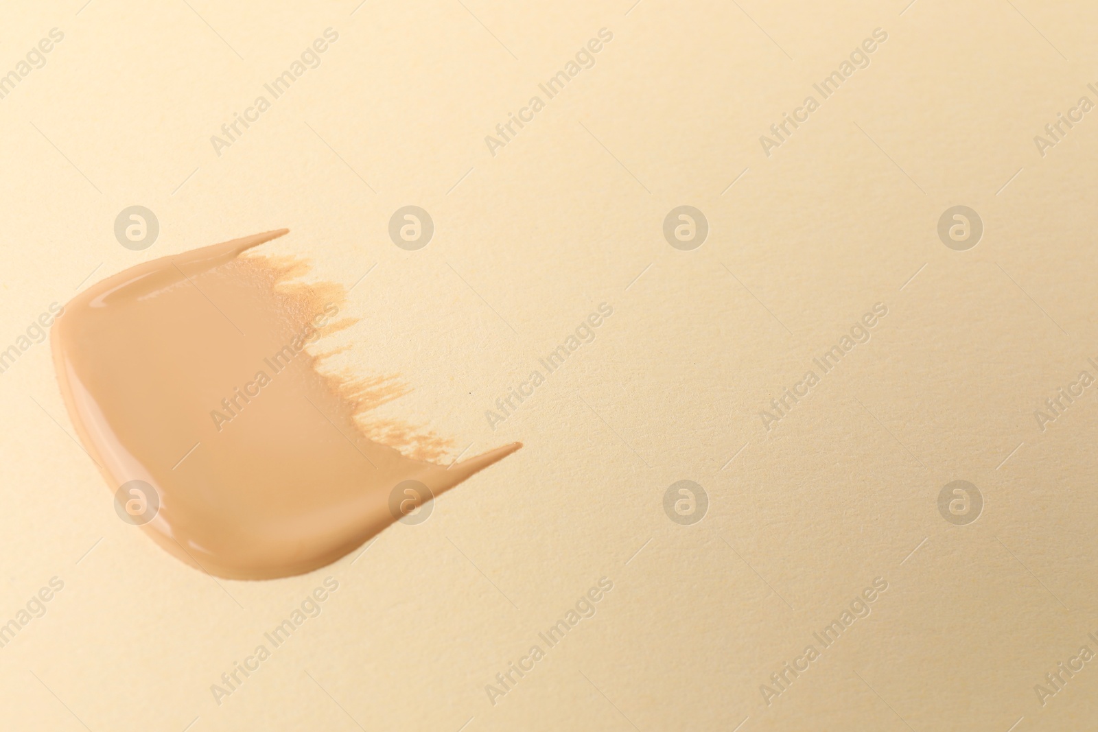 Photo of Sample of foundation on beige background, space for text