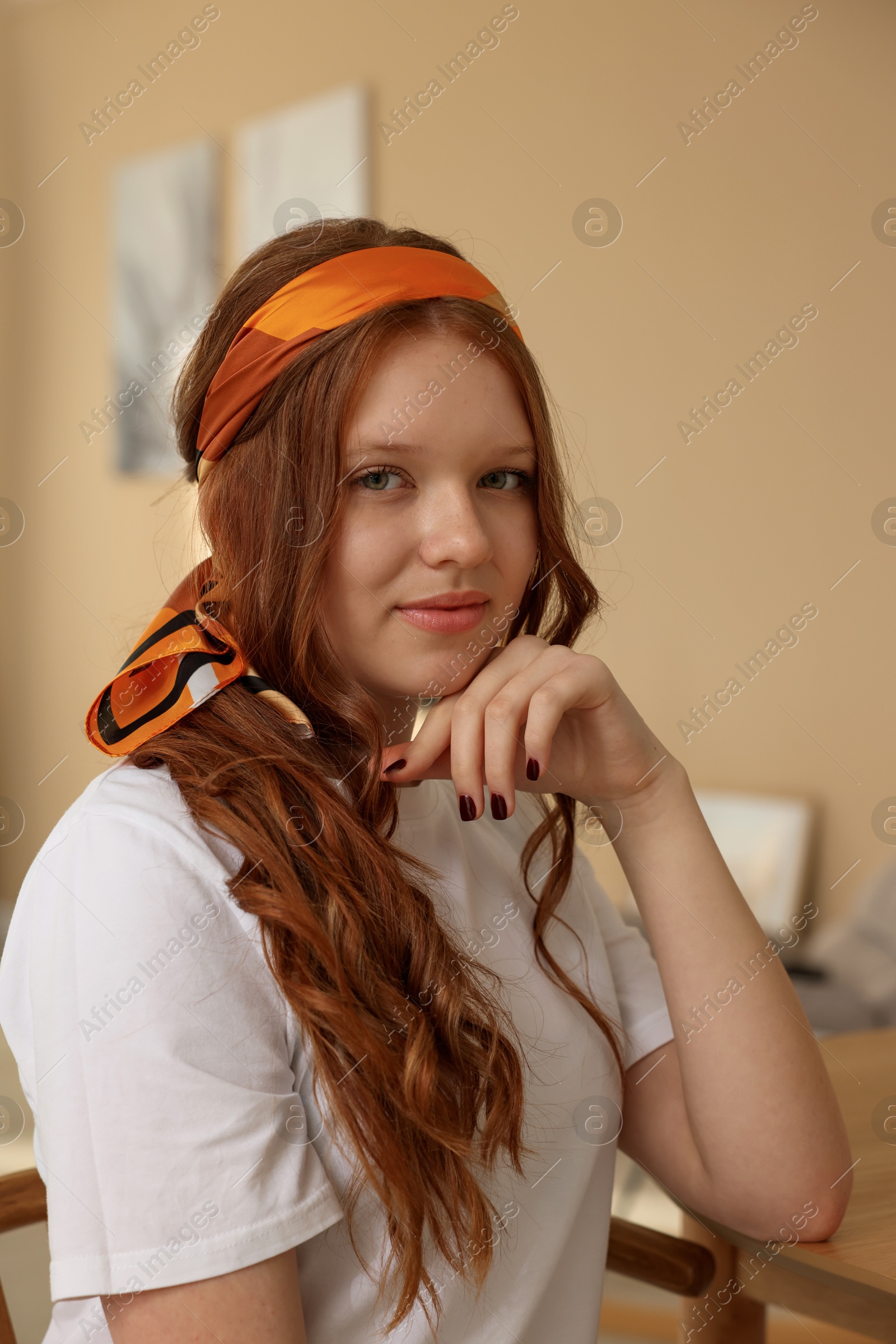 Photo of Red-haired teenage girl with stylish bandana indoors