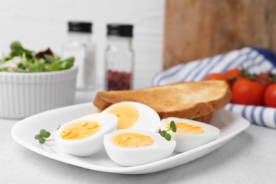 Photo of Hard boiled eggs with bread on light table, closeup