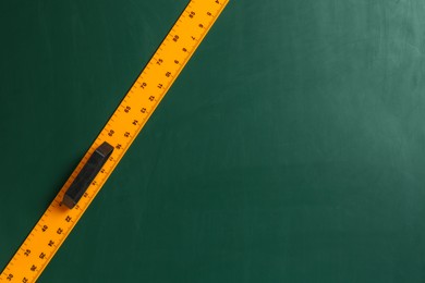 Photo of One ruler on green chalkboard, top view. Space for text