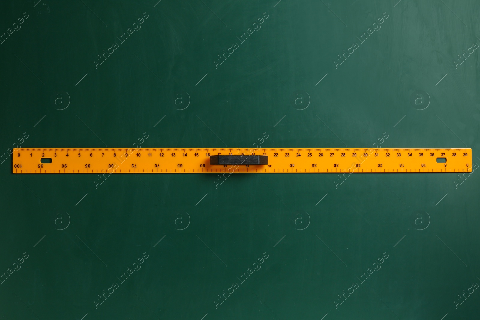 Photo of One ruler on green chalkboard, top view