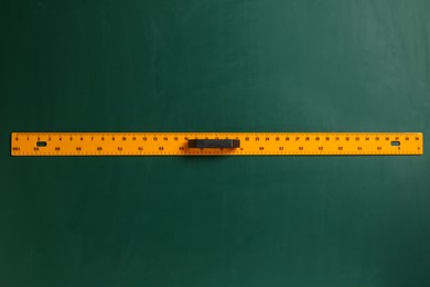 Photo of One ruler on green chalkboard, top view