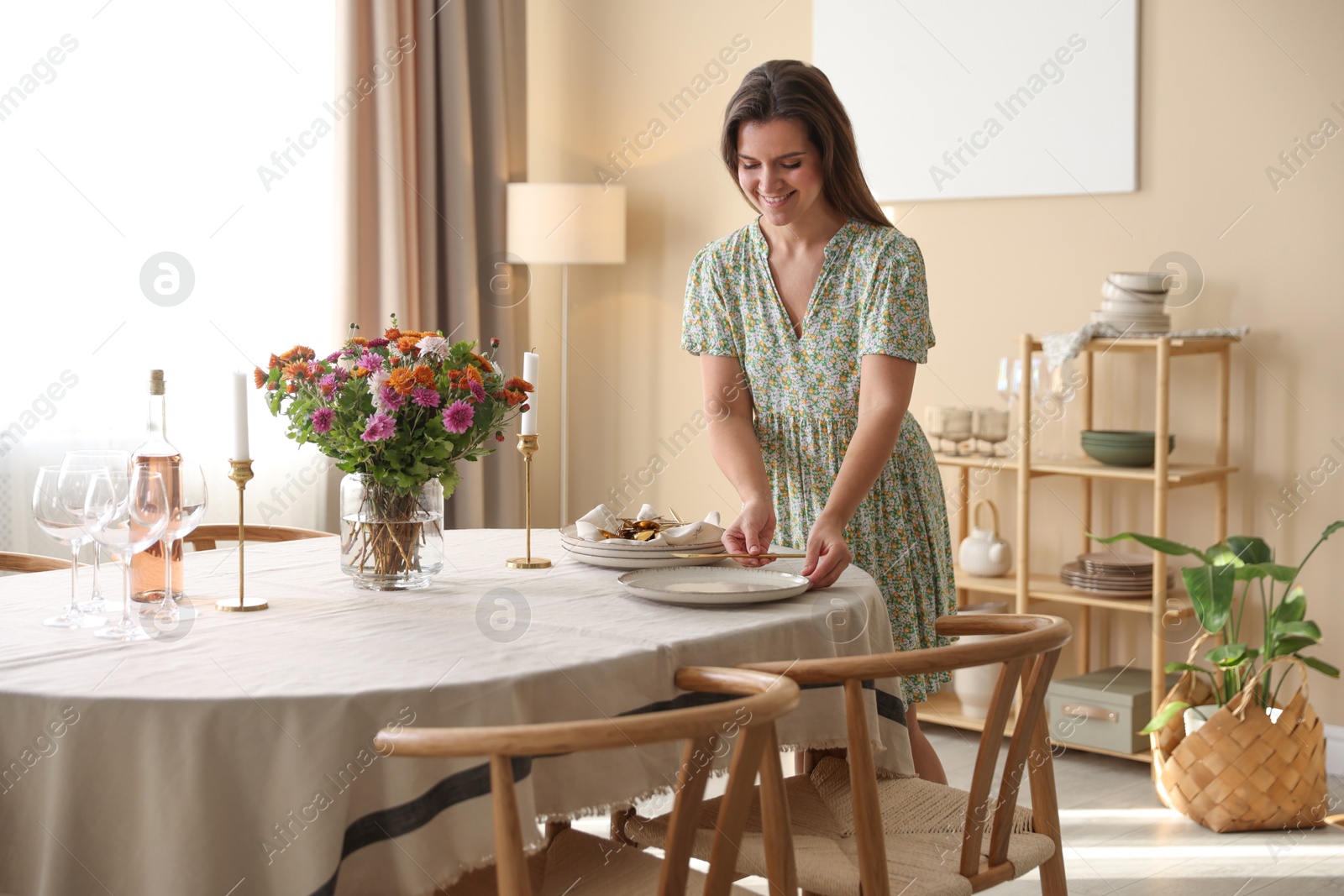 Photo of Woman setting table for dinner at home