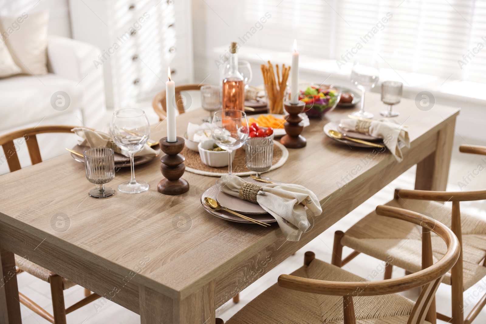 Photo of Stylish table setting with dishware, cutlery and burning candles indoors