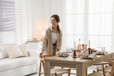 Photo of Woman setting table for dinner at home