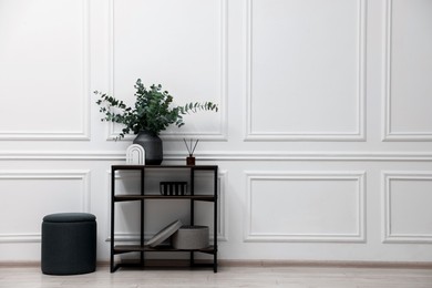 Photo of Console table with decor and pouf in room, space for text. Interior design