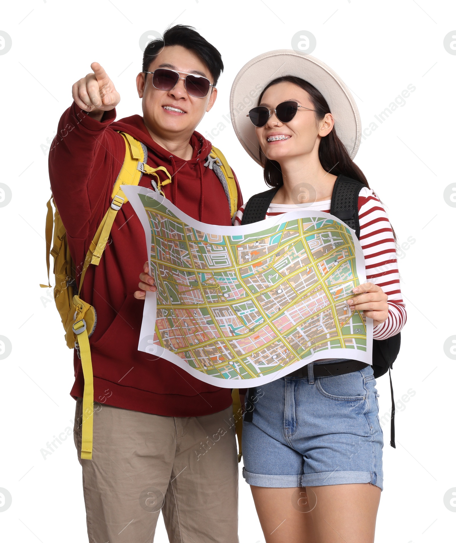 Photo of Happy travellers with map pointing at something on white background