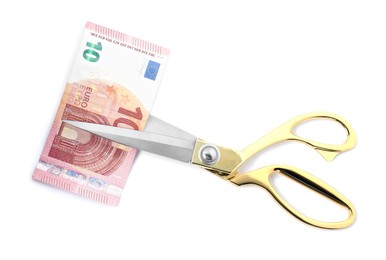 Photo of Scissors with euro banknote isolated on white, top view