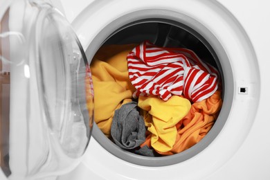 Photo of Modern washing machine with clothes in drum, closeup