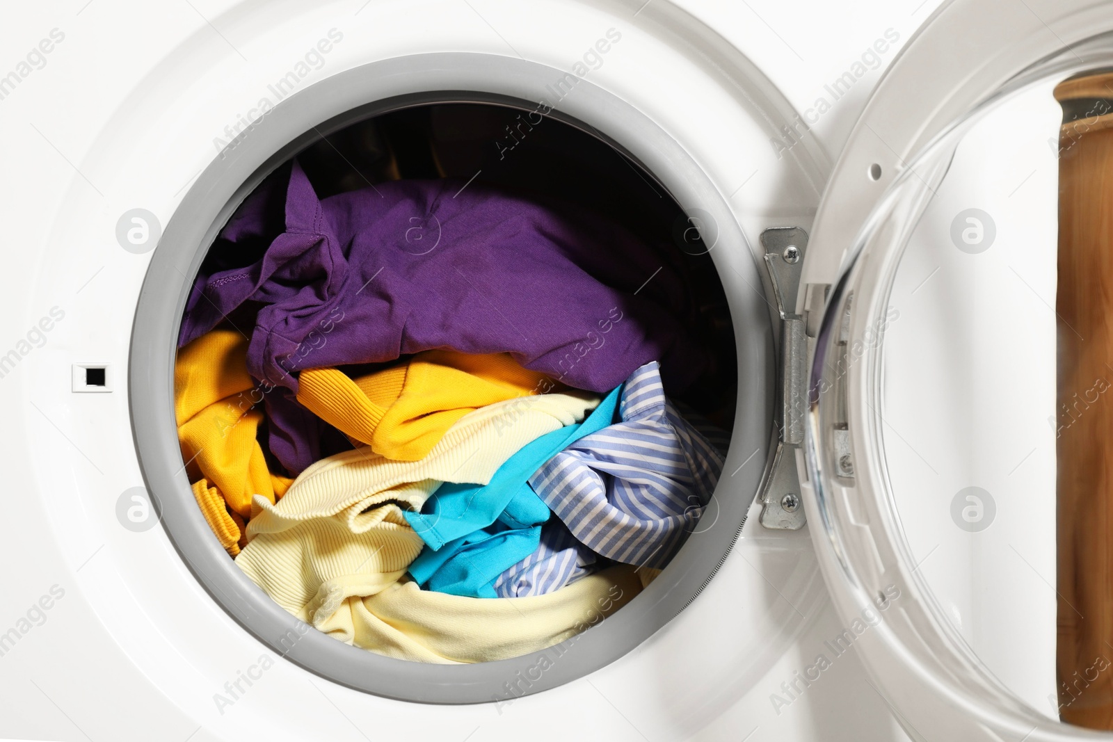 Photo of Modern washing machine with clothes in drum, closeup