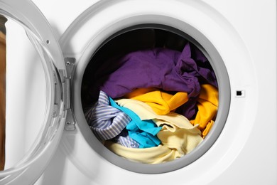 Photo of Modern washing machine with clothes in drum, closeup