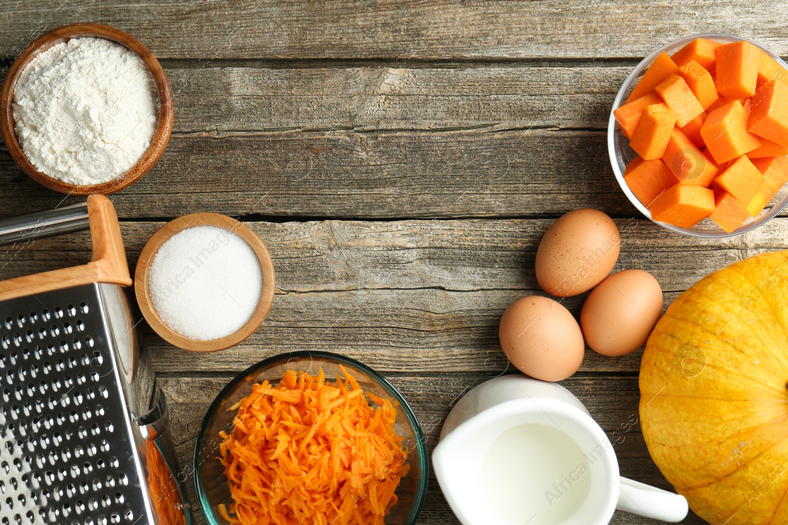 Photo of Different ingredients for pumpkin pancakes on wooden table, flat lay. Space for text