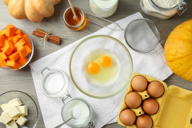 Photo of Different ingredients for pumpkin pancakes on wooden table, flat lay